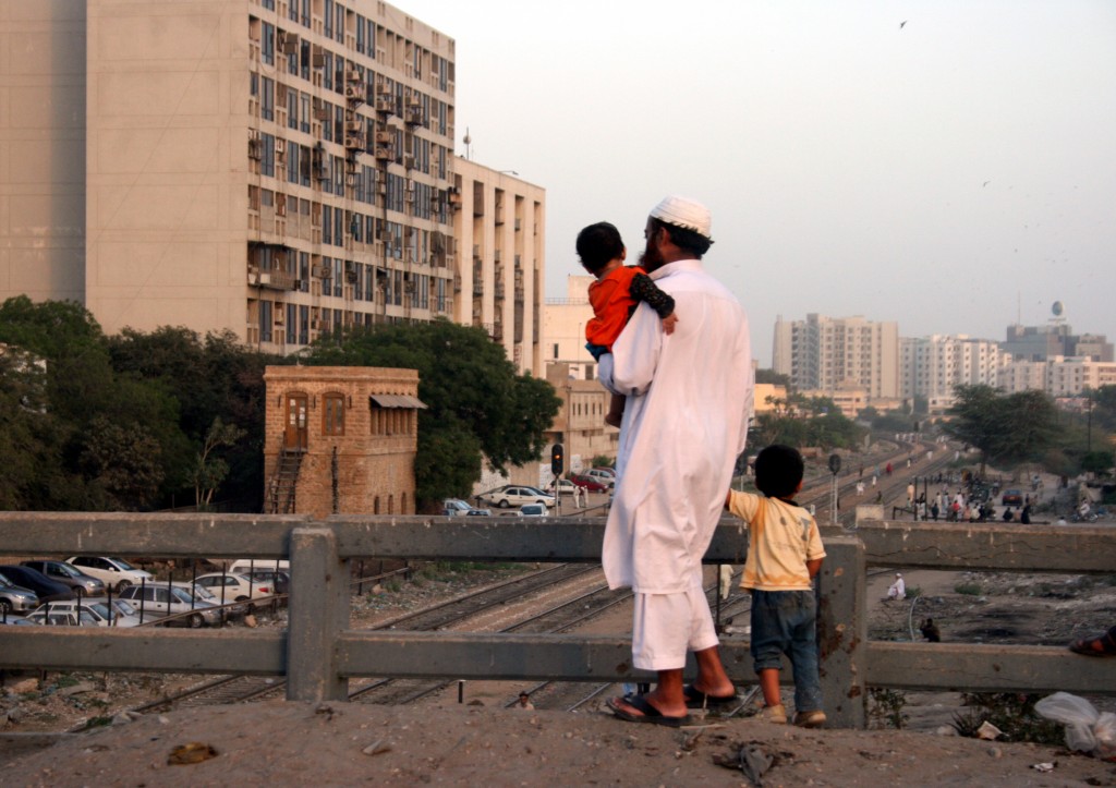 A man and his sons regard the city of Karachi in southern Pakistan. Photo by Larisa Epatko