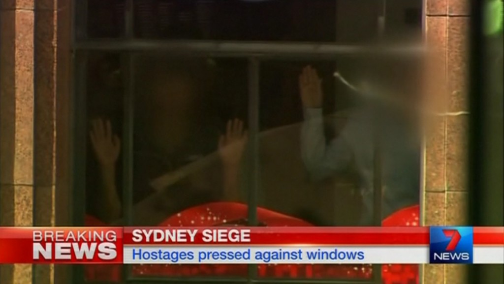 Hands are pressed up against the window of the Lindt cafe, where hostages are being held, in this still image taken from video from Australia's Seven Network on December 15, 2014. 