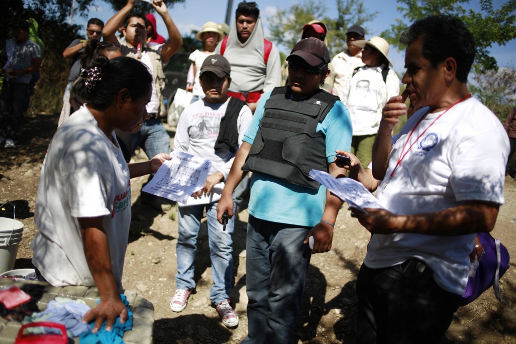 Relatives of the 43 missing students from the Ayotzinapa Teacher Training College distribute flyers during the search for the students in Lomas del Zapatero, on the outskirts of Iguala, Guerrero, January 15, 2015. The Attorney General's office said it had granted a request from the families to allow them to search military barracks throughout Guerrero and other parts of Mexico.  REUTERS/Jorge Dan Lopez (MEXICO - Tags: CRIME LAW EDUCATION POLITICS CIVIL UNREST) - RTR4LLVA