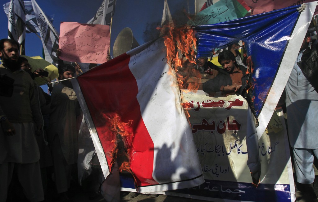 Supporters of the Jamaat-ud-Dawa Islamic organization burn a French flag during a protest against satirical French weekly newspaper Charlie Hebdo, which featured a cartoon of the Prophet Mohammad as the cover of its first edition since an attack by Islamist gunmen, in Peshawar January 16, 2015. REUTERS/Fayaz Aziz (PAKISTAN - Tags: MEDIA CIVIL UNREST POLITICS RELIGION) - RTR4LQEP