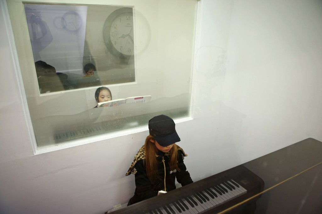 Kim Si-yoon plays the piano during a lesson in Seoul November 20, 2014. Photo by Kim Hong-Ji/Reuters