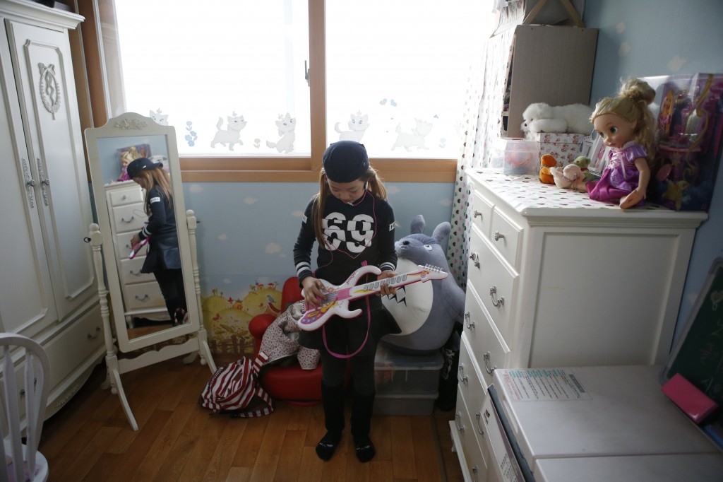 Kim Si-yoon plays a toy guitar at her house in Seoul November 20, 2014. Photo by Kim Hong-Ji/Reuters