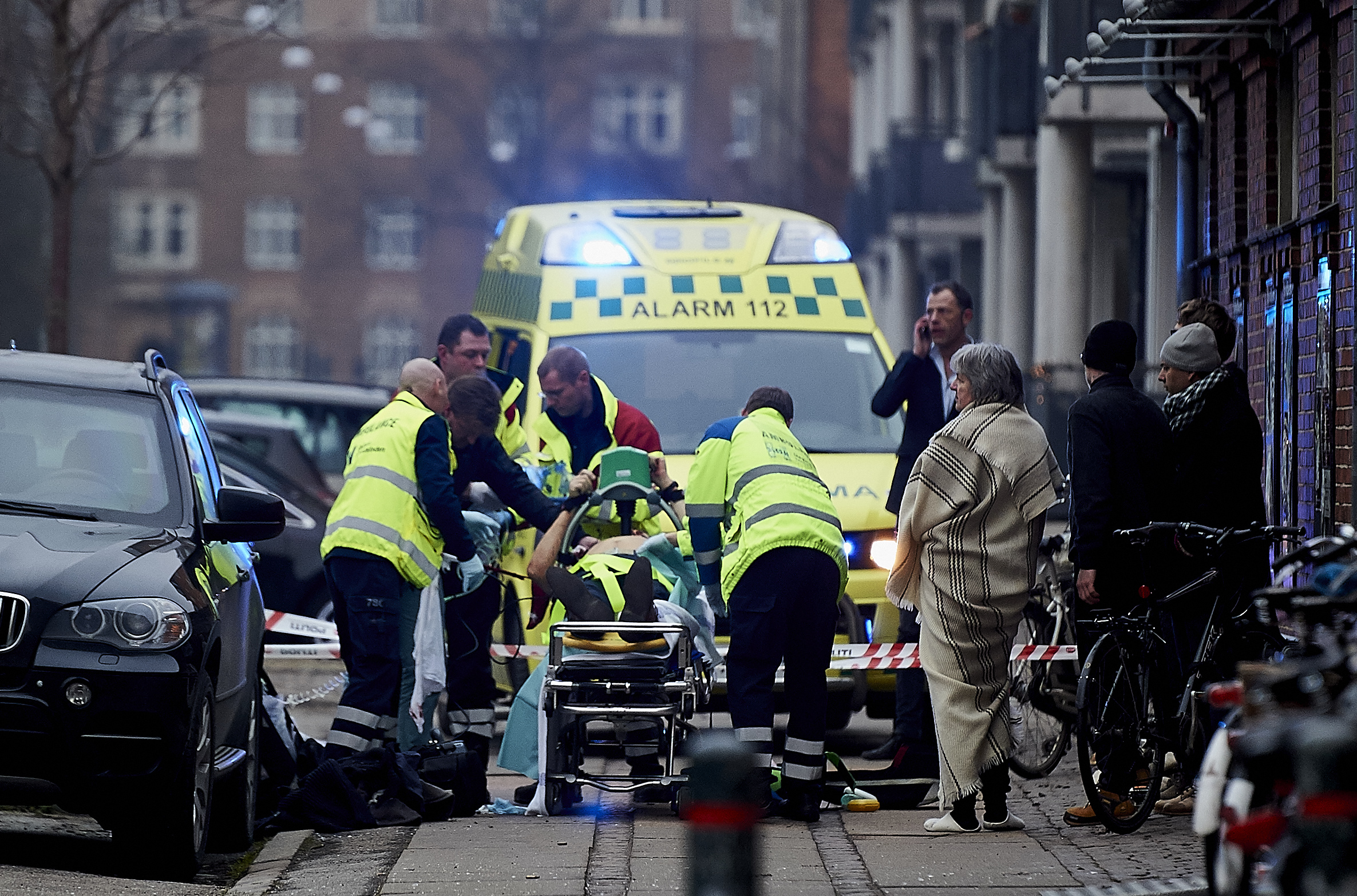 A victim is carried into an ambulance after a shooting incident after a public meeting and discussion arranged by the Lars Vilks Committee about Charlie Hebdo and freedom of speech in the Krudttonden Hall in the Osterbro area on February 14, 2015 in Copenhagen, Denmark. Photo by Lars Rønbøg.