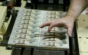An employee checks sheets of the newly-designed $20 bill, coming off the printing press at the U.S. Bureau of Engraving and Printing Western Facility in Fort Worth, Texas on Aug. 19, 2003. Photo by Jeff Mitchell/Reuters
