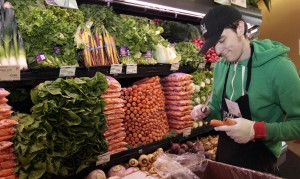 Whole Foods grocery store worker Tim Owen trims the tops of organic carrots in the produce section of the store in Ann Arbor, Michigan, March 8, 2012. Photo by Rebecca Cook/Reuters