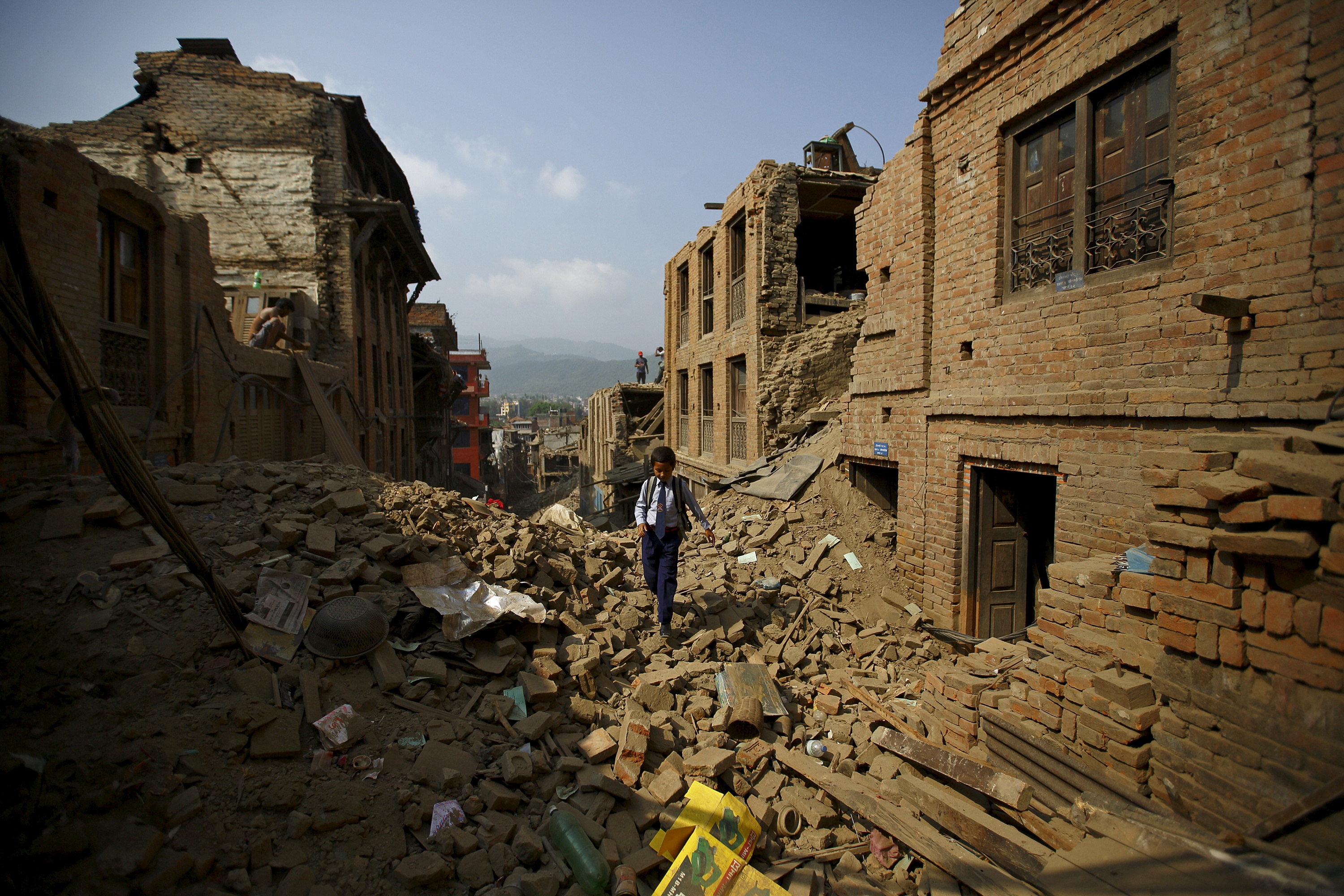 Niraj Ranjitkar, 10, walks along the debris of collapsed houses as he heads toward his school in Bhaktapur, Nepal on May 31, 2015. Photo by Navesh Chitrakar/Reuters
