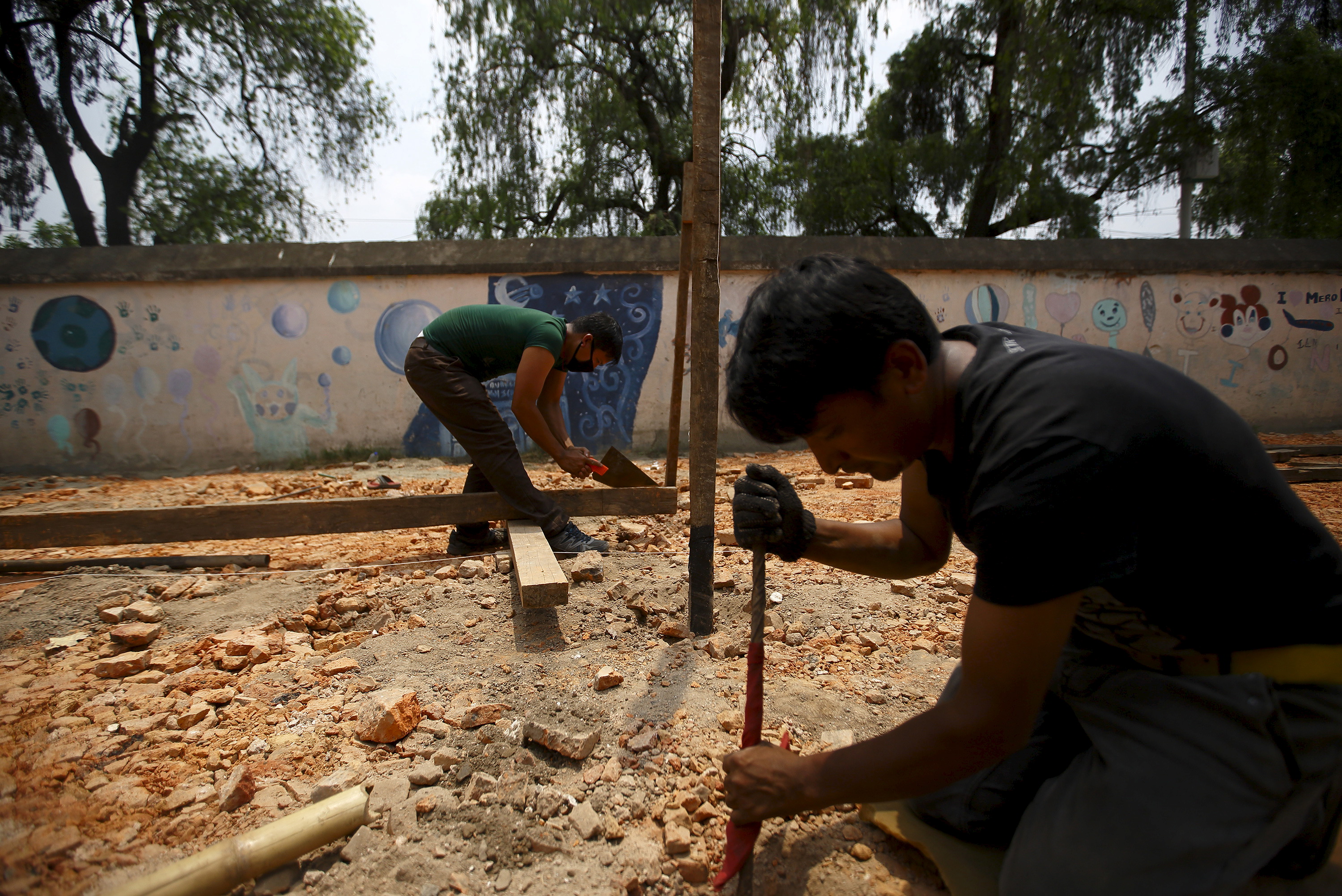 Men work to build a temporary classroom outside of a damaged school in Kathmandu, Nepal on May 29, 2015. Photo by Navesh Chitrakar/Reuters