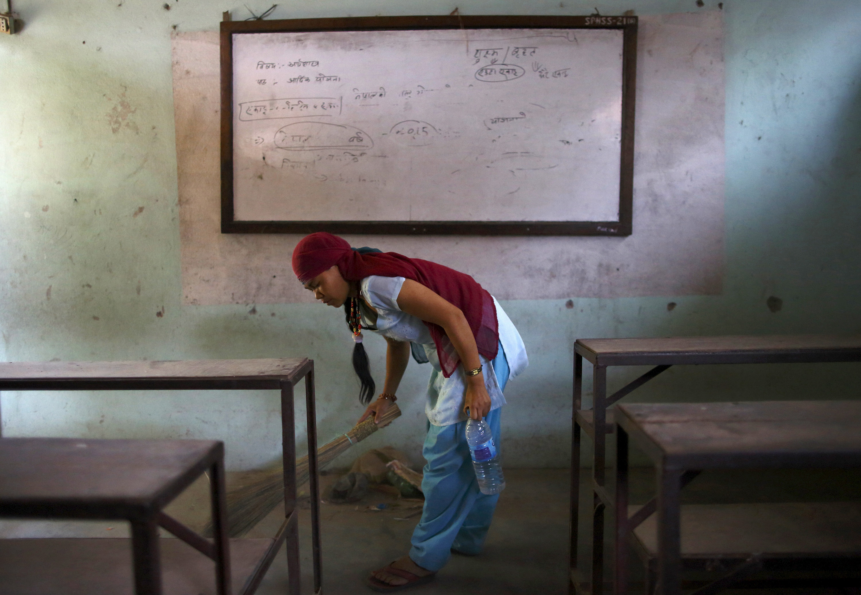 A woman cleans a classroom before the school reopens in Bhaktapur, Nepal on May 31, 2015. Photo by Navesh Chitrakar/Reuters