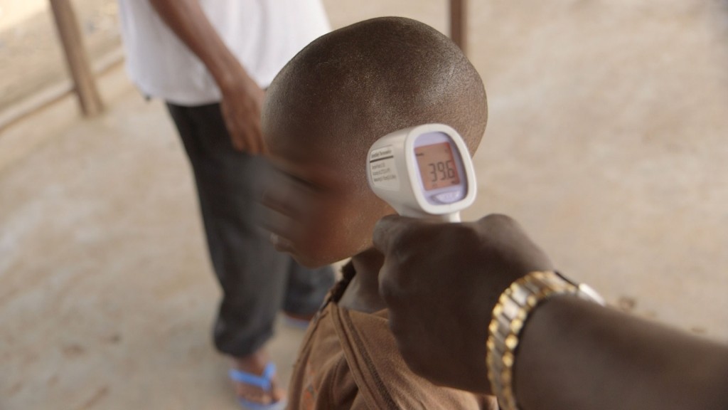 Health workers and family members grow concerned as a 5-year-old boy in Kambia, Sierra Leone, whose mother and father had both contracted Ebola, logs a temperature reading of 103.3 degrees Fahrenheit.  Image by Cameron Hickey