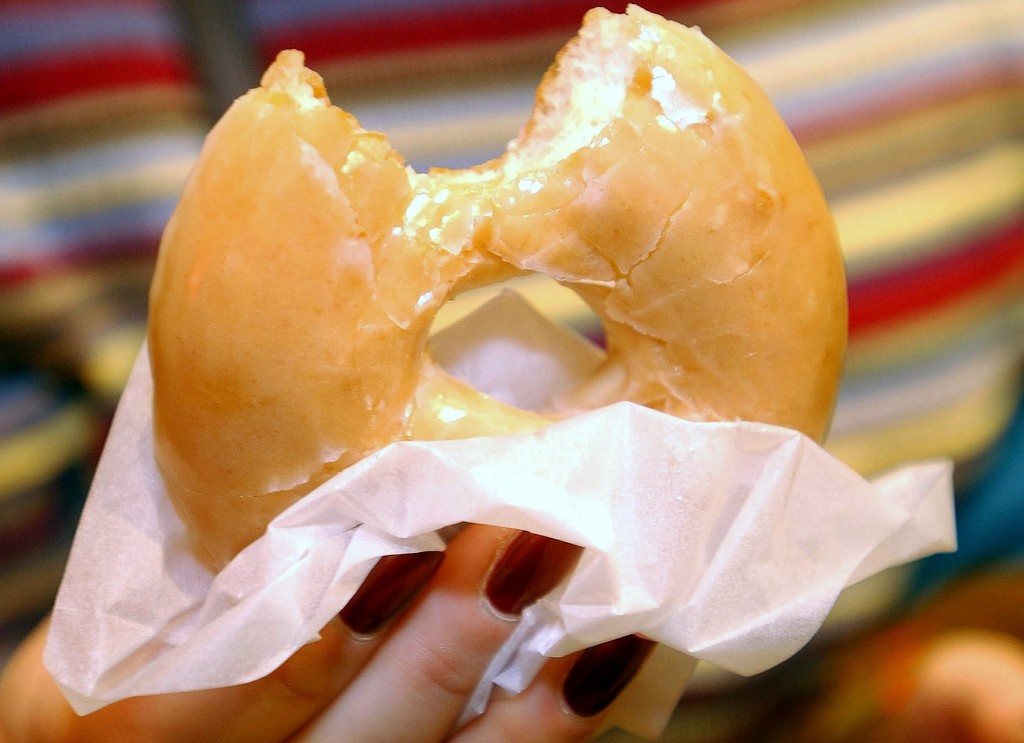 A customer samples a doughnut at the opening of the Krispy Kreme doughnut store at Harrods in London, October, 3, 2003. [The U.S. chain opened its first European outlet in London on Friday.] Photo by Reuters