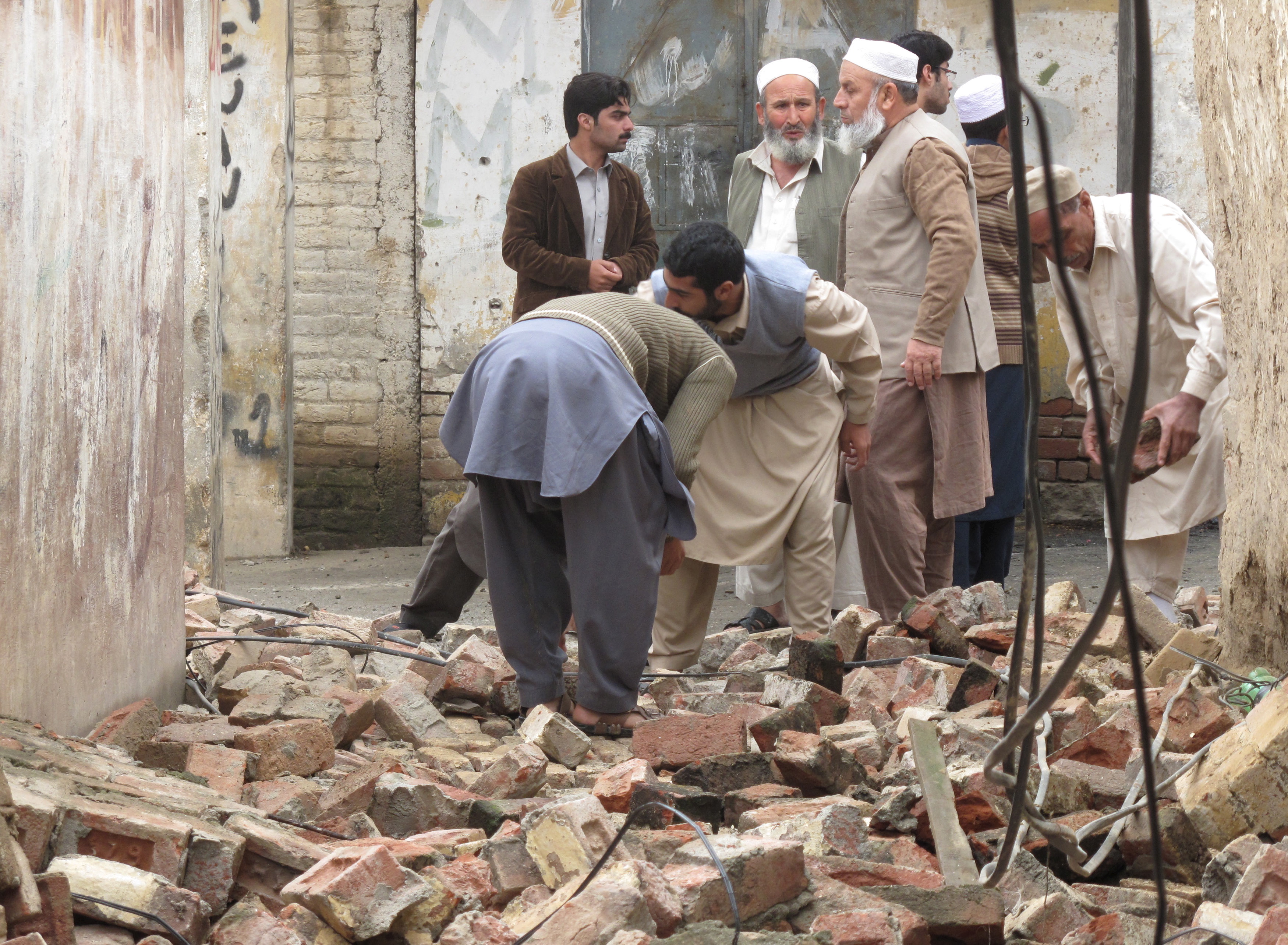 Residents gather in Mingora, Swat, Pakistan, to clear a path through rubble caused by an earthquake in northern Afghanistan on Oct. 26. Photo by Hazrat Ali Bacha/Reuters