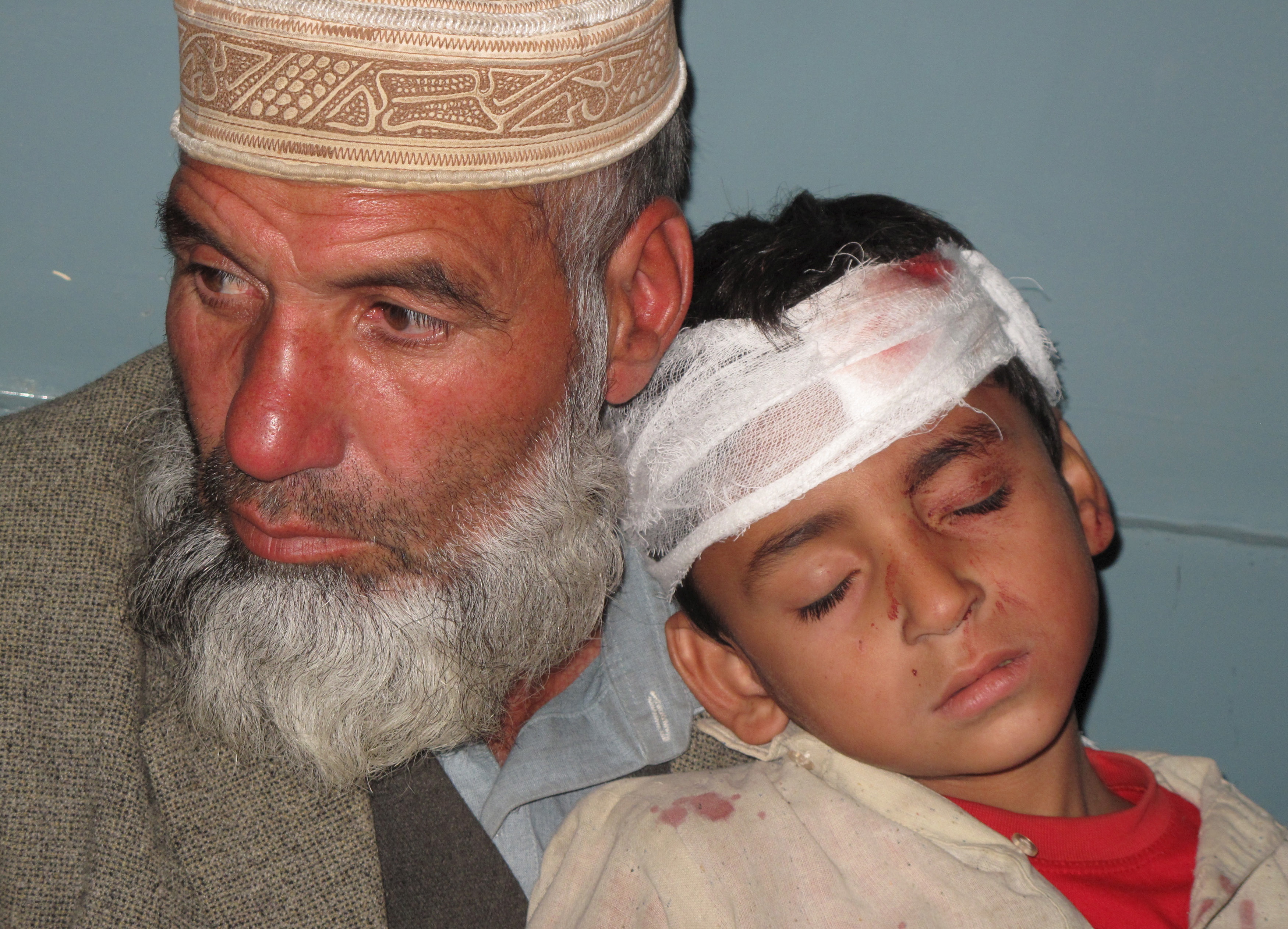A boy, who was injured during an earthquake, leans on his father's shoulder after receiving first aid at hospital in Mingora, Swat, Pakistan on Oct. 26. Photo by Hazrat Ali Bacha/Reuters