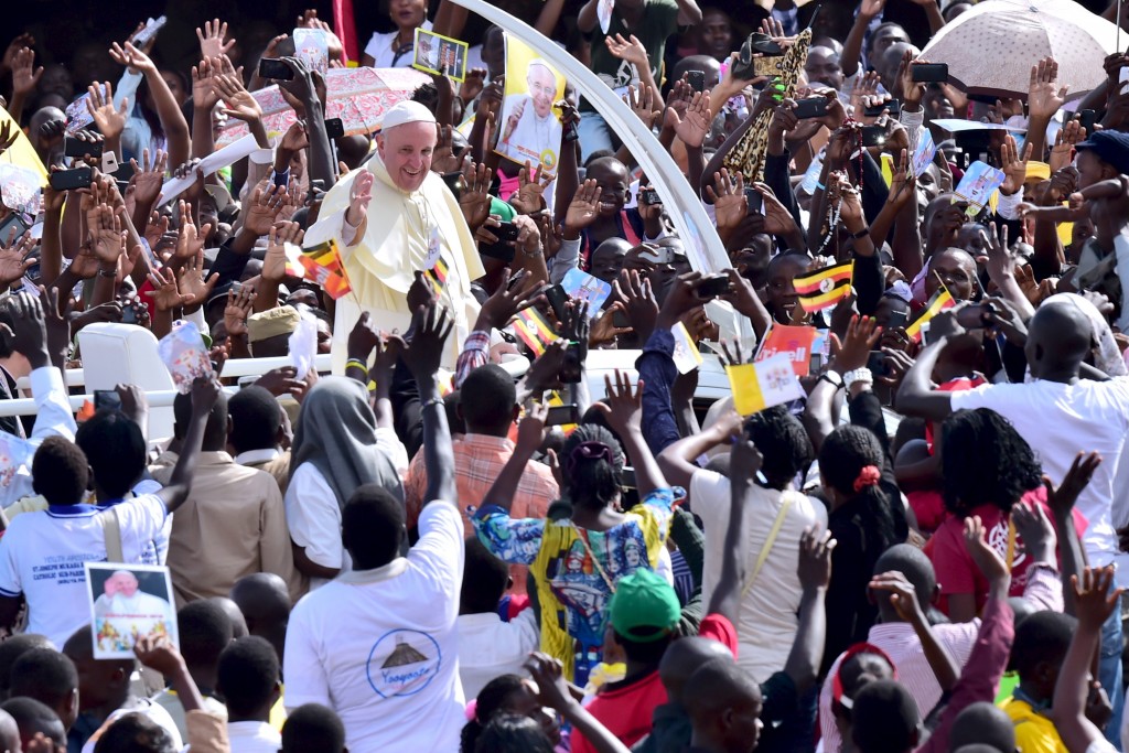 Crowds cheer as Pope Francis arrives at Kololo airstrip in Kampala, November 28, 2015. Pope Francis left Kenya for Uganda where he will spend two days before continuing on to Central African Republic, a country wracked by sectarian conflict. REUTERS/Giuseppe Cacace/Pool - RTX1W8KD