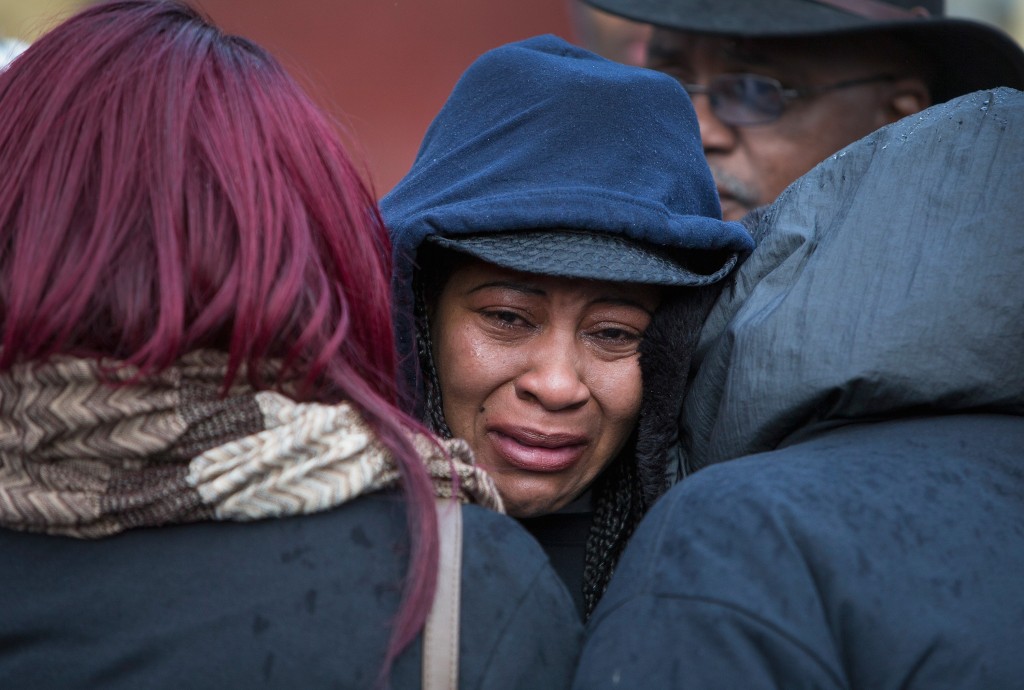 Janet Cooksey is comforted as she listens to speakers talk about the deaths of her son Quintonio LeGrier, and Bettie Jones before the start of a vigil on Saturday in Chicago. Photo by Scott Olson/Getty Images