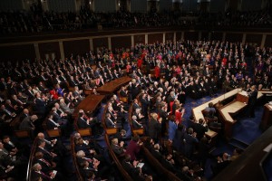 Democratic members of Congress rise to their feet for a standing ovation as Republican members remain seated during U.S. President Barack Obama's State of the Union address to a joint session of Congress in Washington, January 12, 2016. REUTERS/Jonathan Ernst - RTX224XG