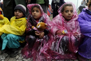 Children are covered with plastic raincoats as stranded refugees wait for the border crossing to reopen near the Greek village of Idomeni, February 28, 2016. Alexandros Avramidis/Reuters 
