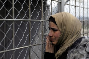 A refugee cries next to the border fence of the Greek-Macedonian borderas  during a protest by stranded refugees who wait for the border crossing to reopen near the Greek village of Idomeni, February 28, 2016. REUTERS/Alexandros Avramidis - RTS8EKV