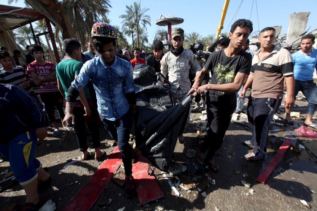Residents carry the body of a victim of a bomb attack at a checkpoint in the city of Hilla, south of Baghdad, March 6, 2016.  Alaa Al-Marjani/Reuters