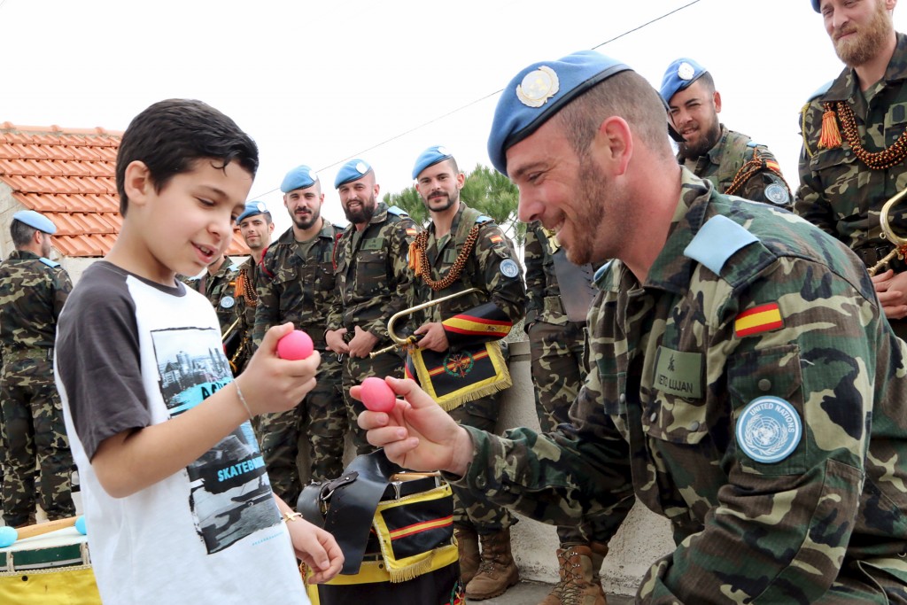 A Spanish member of the United Nations Interim Forces (UNIFIL) breaks his egg with a Lebanese boy after an Easter service in Marjayoun village, southern Lebanon March 27, 2016. REUTERS/Karamallah Daher  - RTSCE71