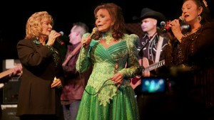 Loretta Lynn (C) performs with her sisters Peggy Sue Wright (L) and Crystal Gayle (R) in "American Masters: Loretta Lynn: Still a Mountain Girl." Image provided by Elliott Halpern/Yap Films Inc.