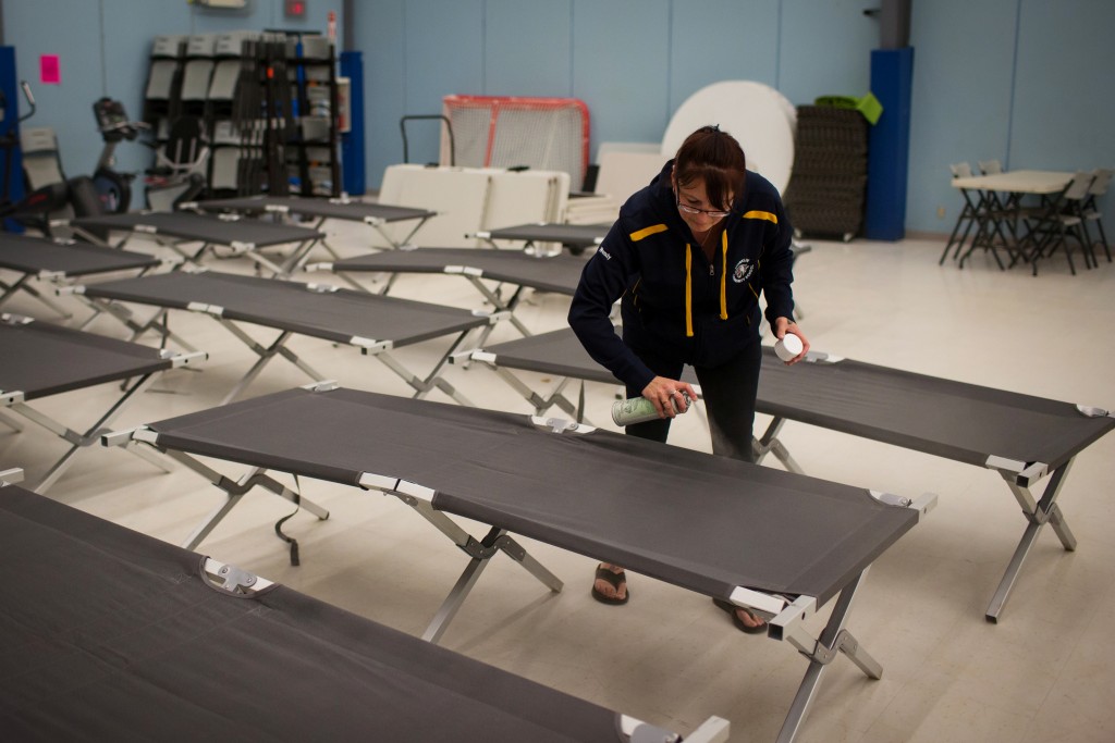 Wendy Tremblay prepares cots for residents evacuating a wildfire in Conklin, Alberta, Canada, on May 3, 2016. Photo by Topher Seguin/Reuters