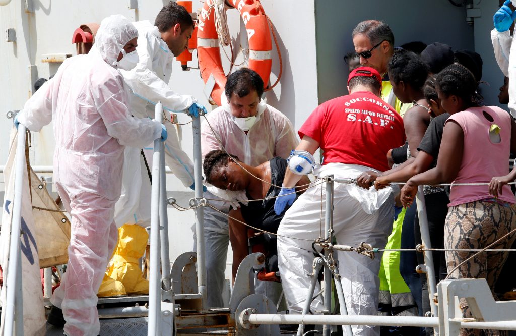 A woman is helped by medical staff abroad the Italian Navy vessel Vega at the Reggio Calabria harbour, southern Italy, May 29, 2016. Photo By Antonio Parrinello/Reuters 