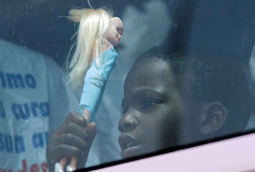 A child holds a doll as he sits in a coach after disembarking from the Italian Navy vessel Vega at the Reggio Calabria harbour, southern Italy, May 29, 2016. Photo By Antonio Parrinello/Reuters 