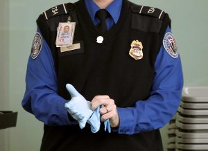 A TSA agent dons rubber gloves at a security checkpoint at Washington Reagan National Airport in Washington, November 22, 2010. Photo by Jason Reed/REUTERS