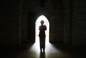 A displaced girl from the minority Yazidi sect, who fled violence in the Iraqi town of Sinjar, worships at their main holy temple Lalish in Shikhan in 2014. Photo by Ahmed Jadallah/Reuters