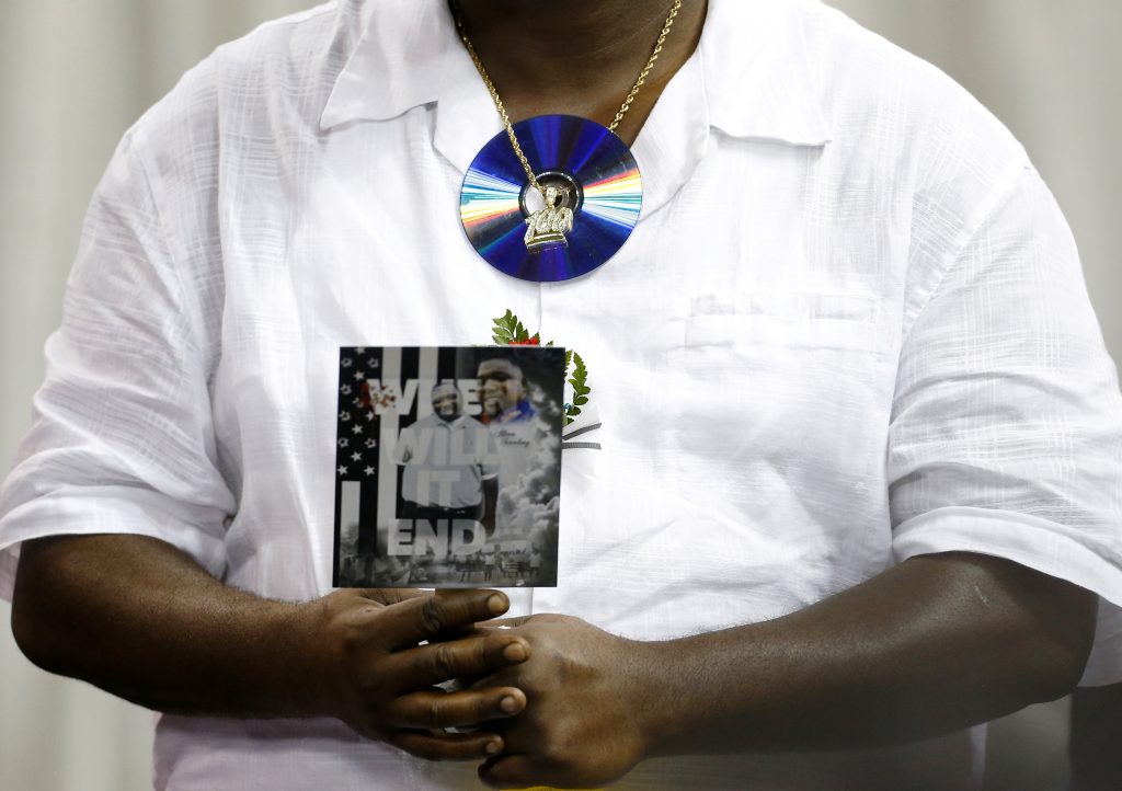 A mourner wears a CD around his neck as he attends the funeral of Alton Sterling, in Baton Rouge, Louisiana, U.S. July 15, 2016. Sterling was shot and killed by Baton Rouge police officers while selling CDs in front of a convenience store. REUTERS/Jonathan Bachman - RTSI6KM