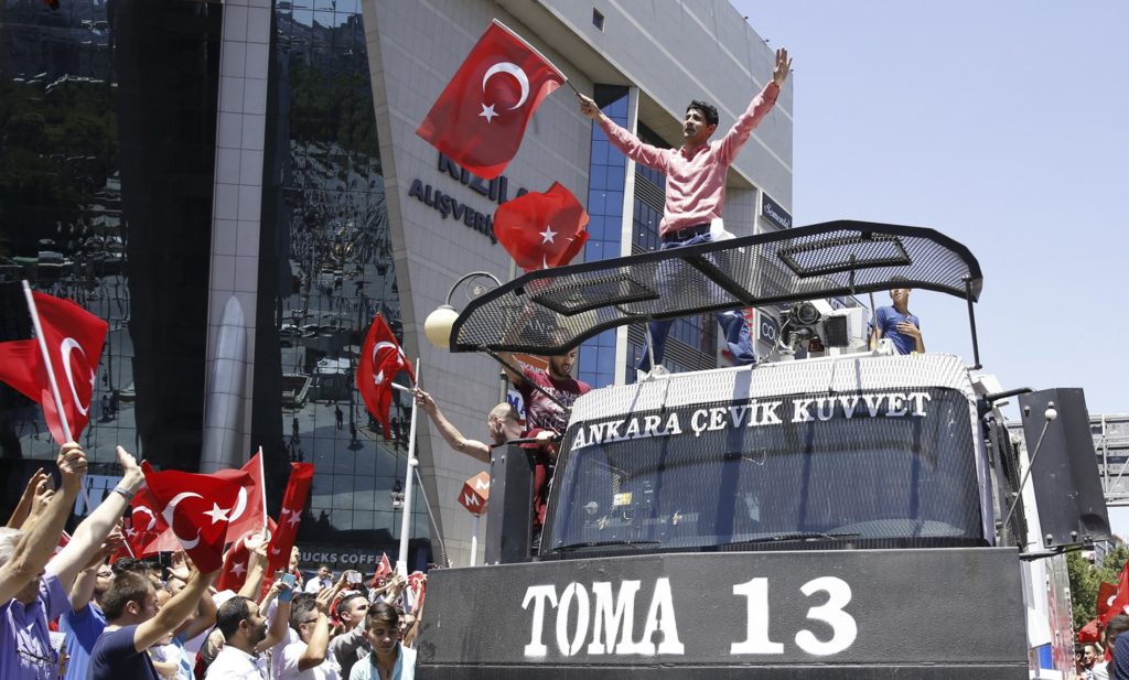 Supporters of Turkish President Tayyip Erdogan celebrate with flags on top of a police car in Ankara, Turkey, July 16, 2016. REUTERS/Tumay Berkin - RTSI9VZ