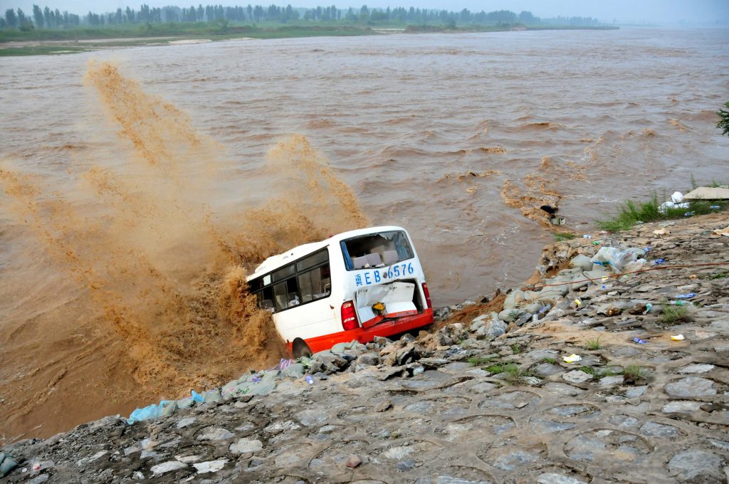 An abandoned bus filled with sand bags is used to build a makeshift dike at a flooded area in Xingtai, Hebei Province, China, July 21, 2016. Picture taken July 21, 2016. REUTERS/Stringer ATTENTION EDITORS - THIS IMAGE WAS PROVIDED BY A THIRD PARTY. EDITORIAL USE ONLY. CHINA OUT. TPX IMAGES OF THE DAY - RTSJAMQ