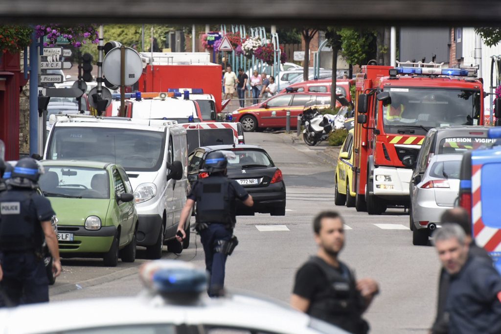 Police and rescue workers stand at the scene after two assailants had taken five people hostage in the church at Saint-Etienne-du -Rouvray near Rouen in Normandy, France, July 26, 2016. Two attackers killed a priest with a blade and seriously wounded another hostage in a church in northern France on Tuesday before being shot dead by French police. REUTERS/Steve Bonet