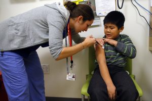 A nurse at a clinic in Boston gives a child an influenza vaccine injection. Photo by Brian Snyder/Reuters.