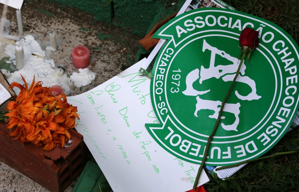 Flowers and messages are seen next to a Chapecoense soccer team flag in tribute to their players in front of the Arena Conda stadium in Chapeco, Brazil, November 29, 2016. REUTERS/Paulo Whitaker