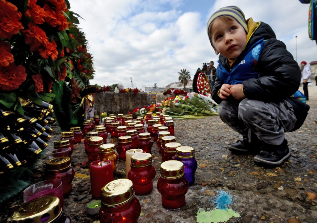 Residents of Sochi, Russia, bring flowers and candles to the pier near the airplane crash site. Photo by Dmitry Korotayev/Kommersant via Getty Images