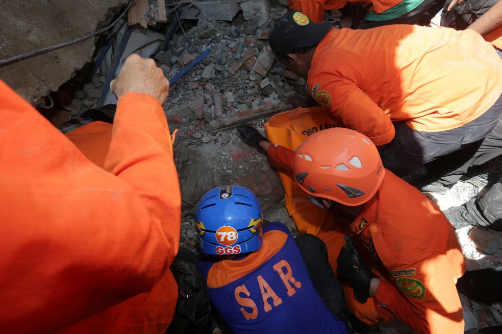 Rescue workers try to remove a victim from a collapsed building following a Dec. 7 earthquake in Lueng Putu, Pidie Jaya in the northern province of Aceh, Indonesia. Antara Foto/Irwansyah Putra/via REUTERS