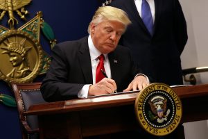 U.S. President Donald Trump signs an executive order to impose tighter vetting of travelers entering the United States, at the Pentagon in Washington, U.S., January 27, 2017. The executive order signed by Trump imposes a four-month travel ban on refugees entering the United States and a 90-day hold on travelers from Syria, Iran and five other Muslim-majority countries. Picture taken January 27, 2017. REUTERS/Carlos Barria - RTSXWMI