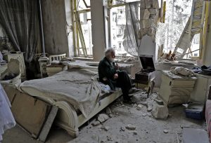 Mohammed Mohiedin Anis, or Abu Omar, 70, smokes his pipe as he sits in his destroyed bedroom listening to music on his gramophone in Aleppo's formerly rebel-held al-Shaar neighborhood on March 9. Photo by Joseph Eid/AFP/Getty Images
