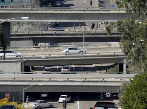 Cars travel on city streets and highway overpasses in San Diego
