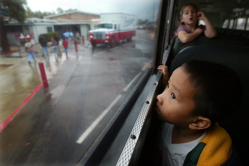 Pao Ge Vang, age 5 looks out of the school bus on his way home after his second day in kindergarten 4 in Fresno, Californi...