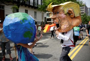 Protesters dressed as the earth and U.S. President Donald Trump pretend to fight during the Peoples Climate March near the White House in Washington