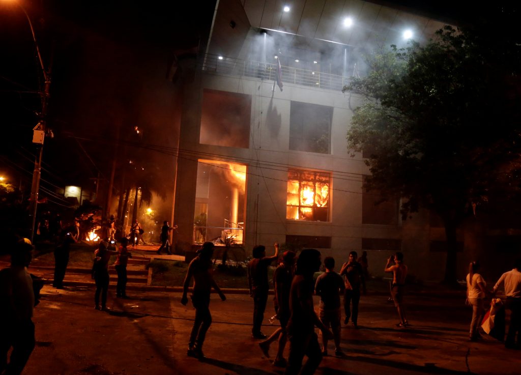 Protestors set fire to the Congress building during a demonstration against a possible change in the law to allow for pres...