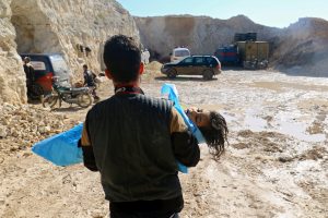 A man carries the body of a child away from the scene of airstrikes in Idlib in northern Syria on April 4. Photo by Ammar Abdullah/Reuters