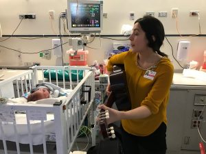 A music therapist plays guitar for babies admitted to the NICU. Photo by Terry Rubin