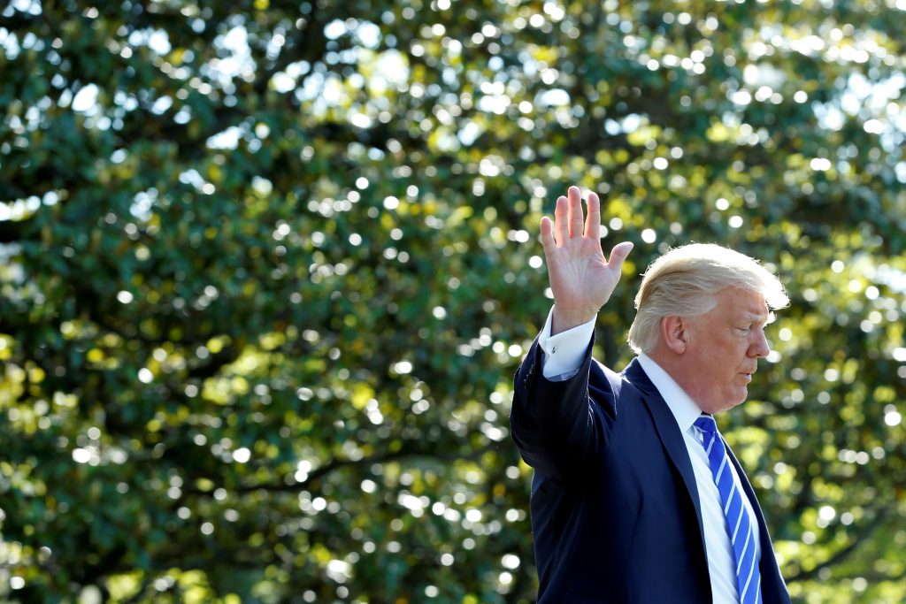 President Donald Trump waves as he walks on the South Lawn of the White House in Washington, D.C., before his departure to...