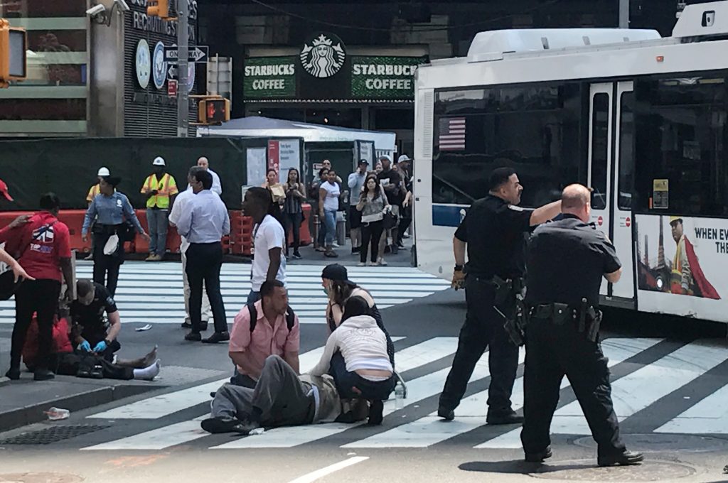 First responders are at the scene as people help injured pedestrians after a vehicle struck pedestrians on a sidewalk in T...