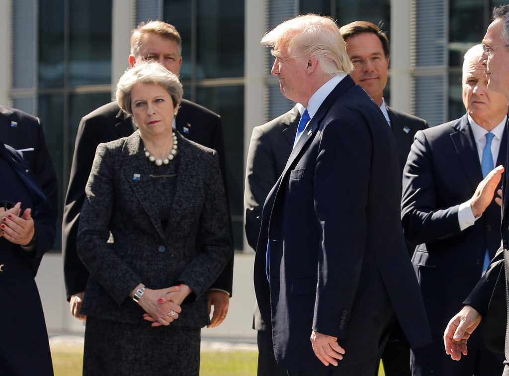 U.S. President Donald Trump (R) walks past Britain's Prime Minister Theresa May at the start of the NATO summit at their n...