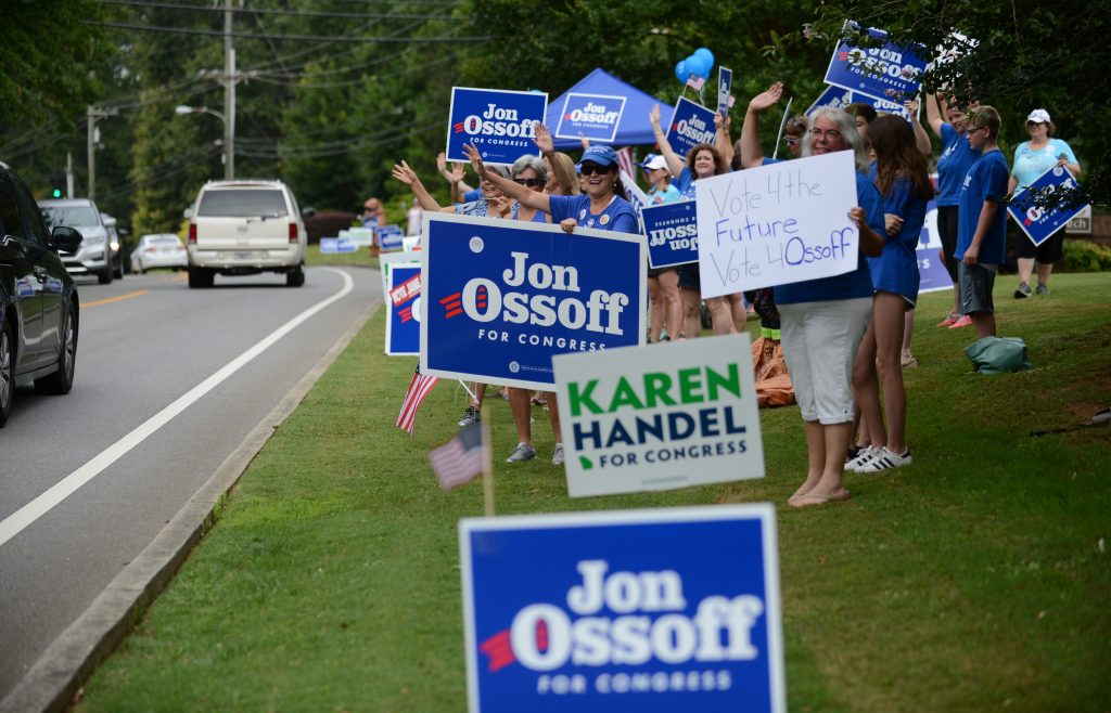Supporters for Georgia 6th Congressional District Democratic candidate Jon Ossoff rally and wave at passing cars amid sign...