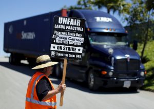 A striking truck driver walks a picket line at a Pacer Cartage facility in Otay Mesa, California